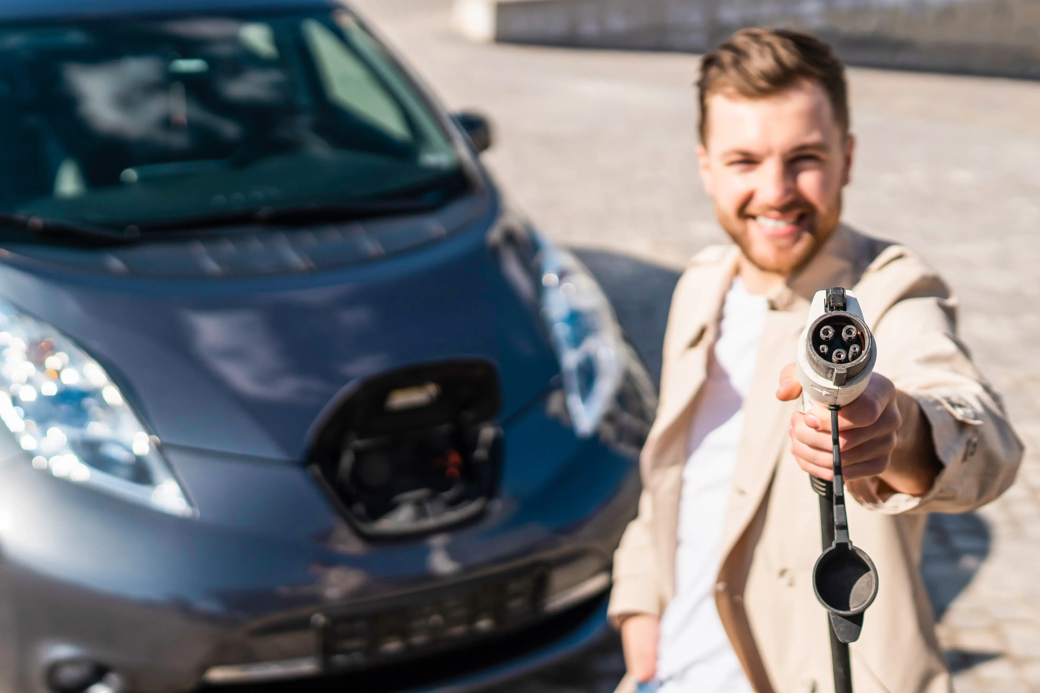 Hombre con coche ecológico enchufable